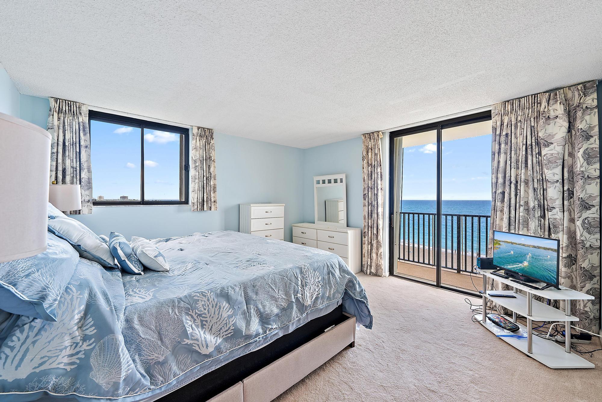 400 Ocean Trail Way, Unit 601 Jupiter, FL 33477 - Photo 27 of 42 a bedroom with a large bed and a balcony
