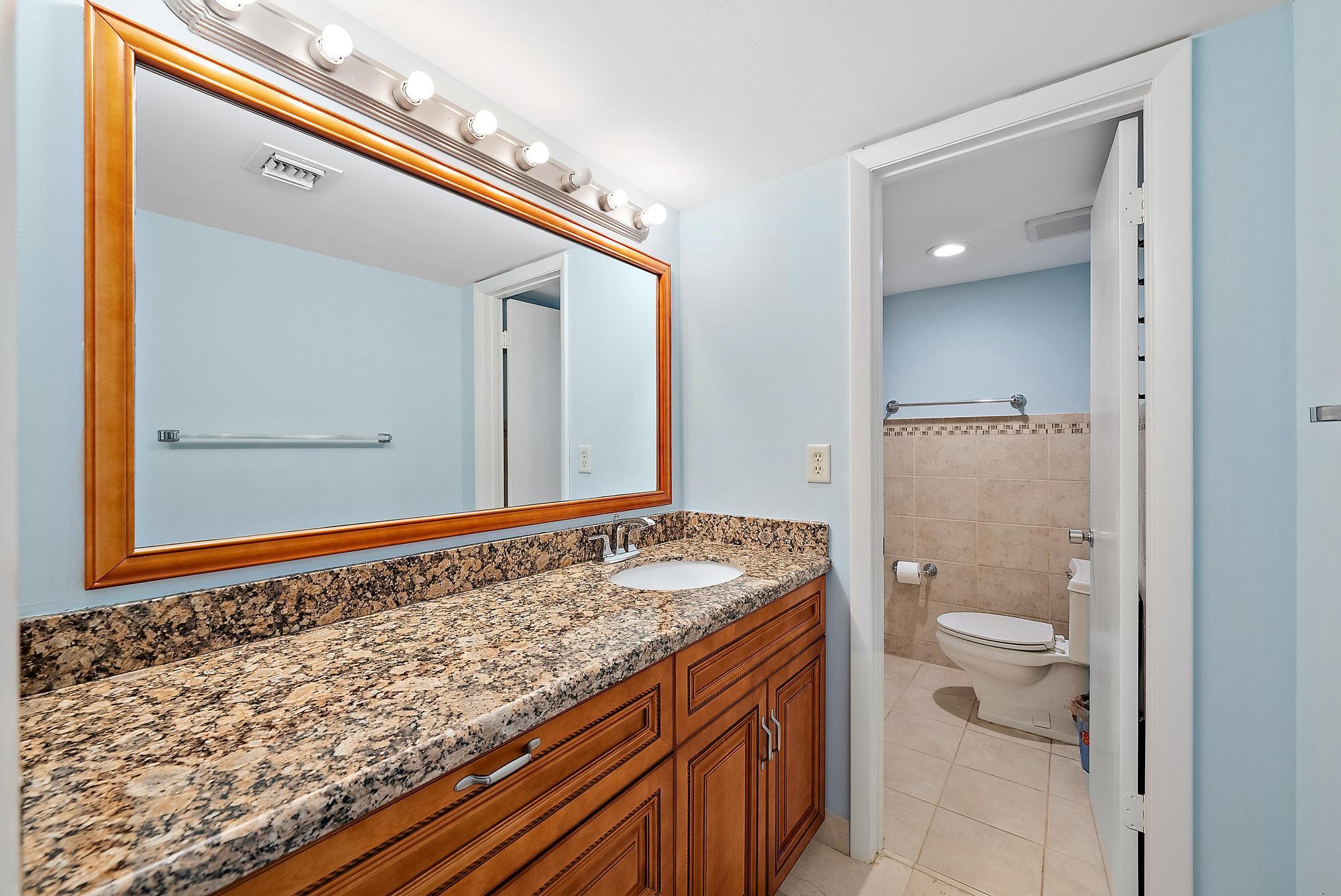 400 Ocean Trail Way, Unit 601 Jupiter, FL 33477 - Photo 31 of 42 a bathroom with a granite countertop sink and a mirror