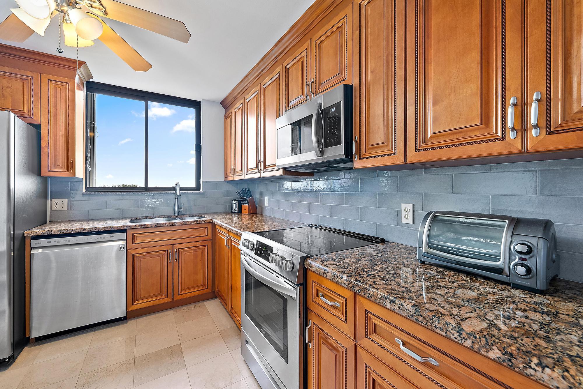 400 Ocean Trail Way, Unit 601 Jupiter, FL 33477 - Photo 34 of 42 a kitchen with stainless steel appliances granite countertop a stove a sink and dishwasher