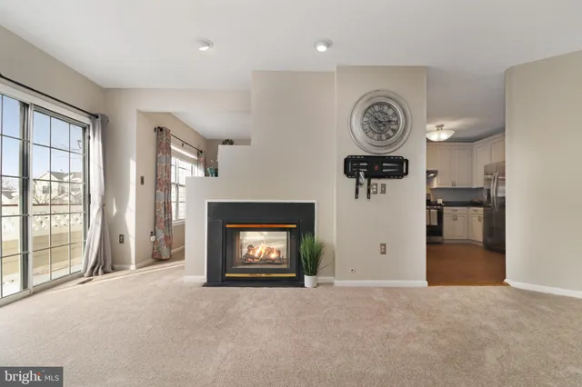 a view of a livingroom with a fireplace a fridge and wooden floor