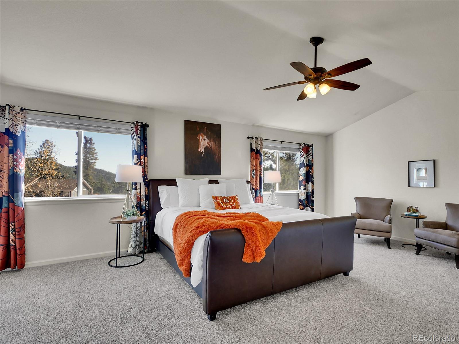 13586 Wamblee Trail Conifer, CO 80433 - Photo 11 of 38 a bed room with a bed and a chandelier