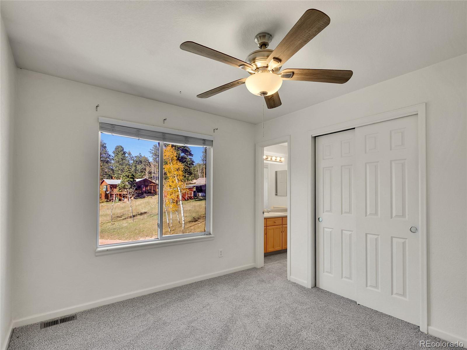 13586 Wamblee Trail Conifer, CO 80433 - Photo 19 of 38 an empty room with window and ceiling fan