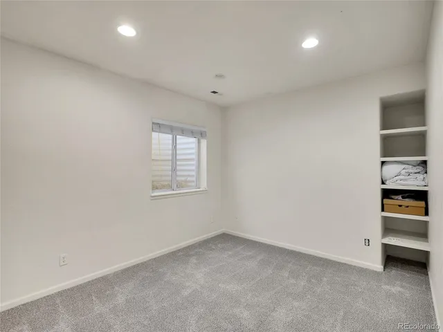 an empty room with a fireplace and window