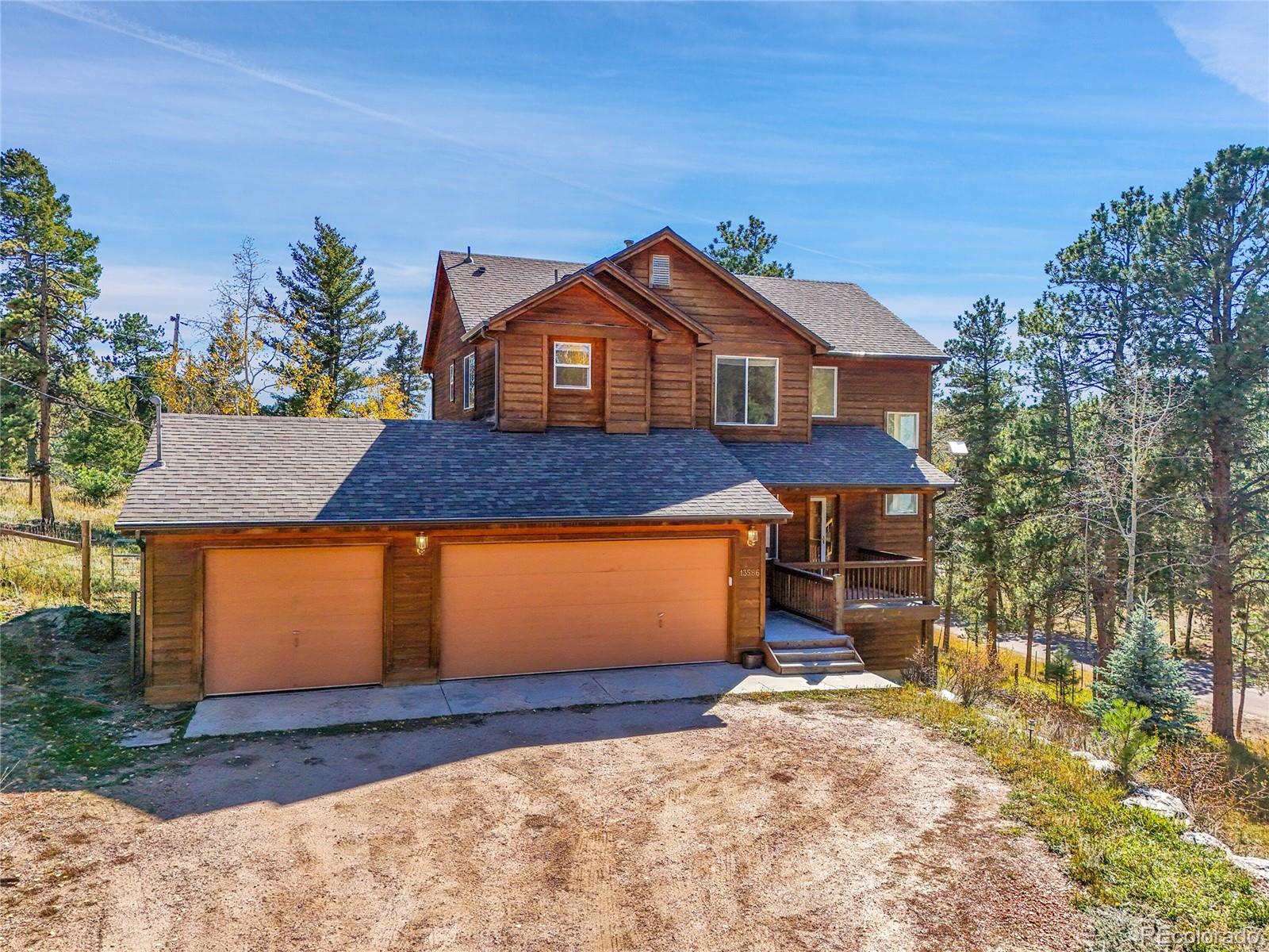 13586 Wamblee Trail Conifer, CO 80433 - Photo 32 of 38 a front view of a house with a yard and garage