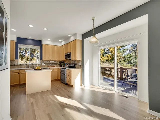 a kitchen with white cabinets and wooden floor