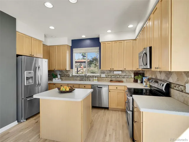 a kitchen with a refrigerator a sink and cabinets