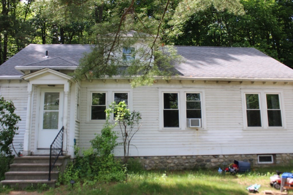 a front view of a house with a yard and potted plants