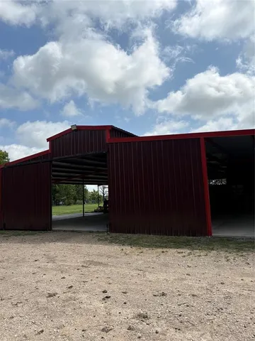 a view of a backyard with large trees and wooden fence