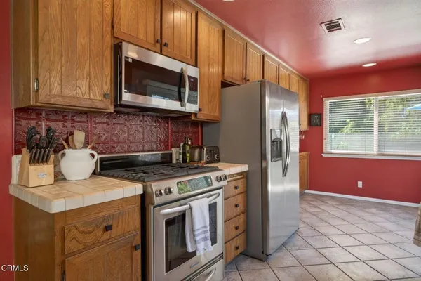 a kitchen with stainless steel appliances granite countertop a stove a microwave and a refrigerator