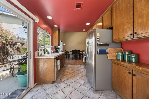 a kitchen view with cabinets a counter and a view of living room