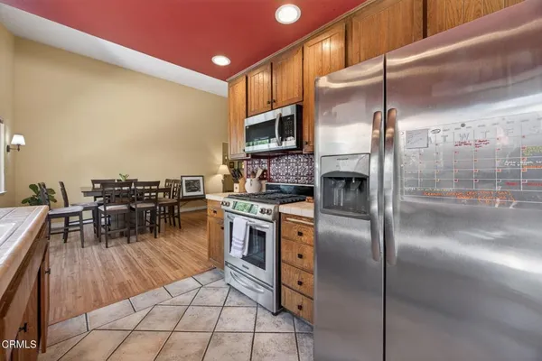 a kitchen with stainless steel appliances granite countertop a refrigerator a stove and a sink