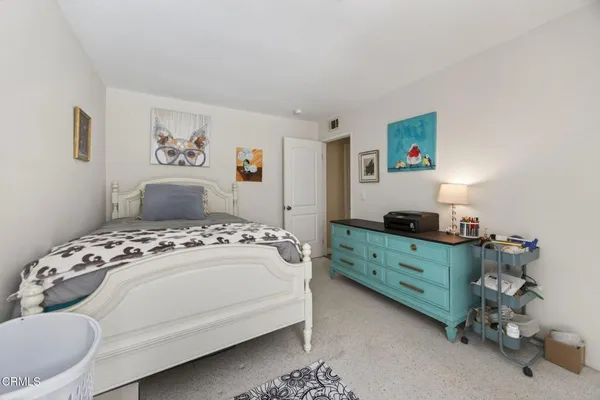 a bedroom with a bed and a dresser in it