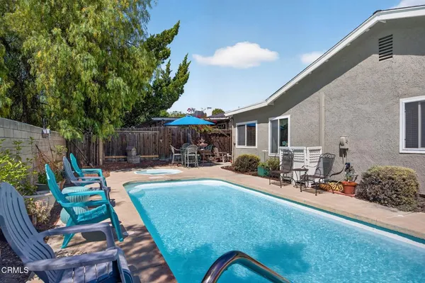 a view of a backyard with table and chairs potted plants and a barbeque