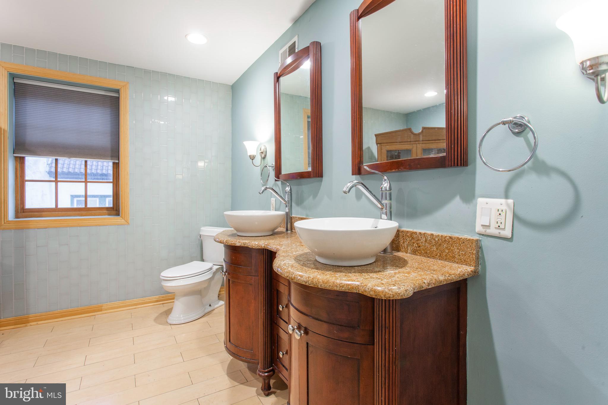 4436 Sansom Street Philadelphia, PA 19104 - Photo 28 of 31 a bathroom with a granite countertop sink and a mirror