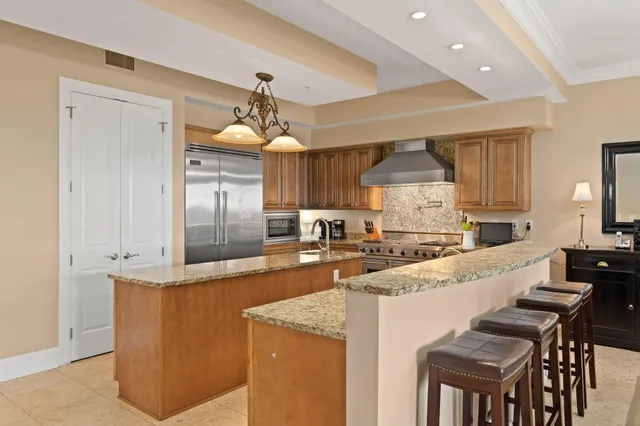 a large kitchen with granite countertop a island a sink stainless steel appliances and cabinets