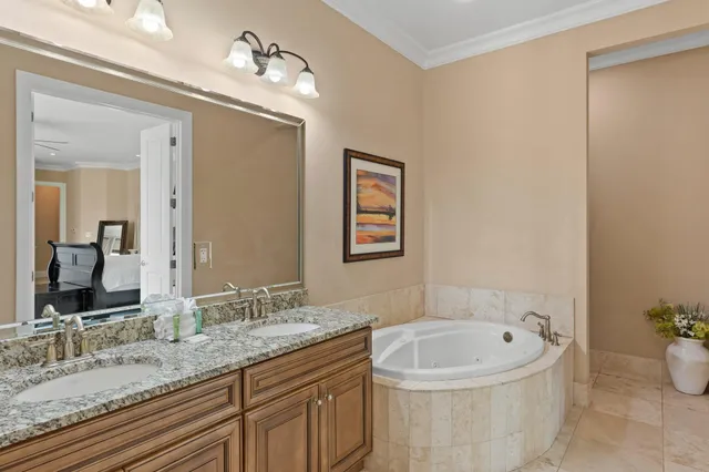 a bathroom with a granite countertop sink and a bathtub