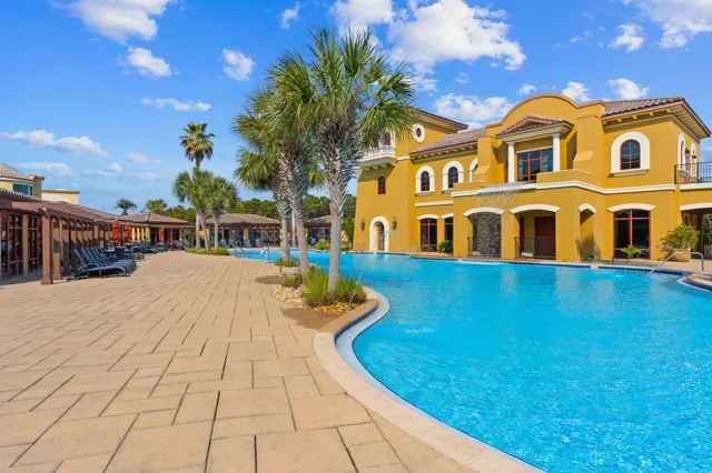 a view of a house with pool and sitting area