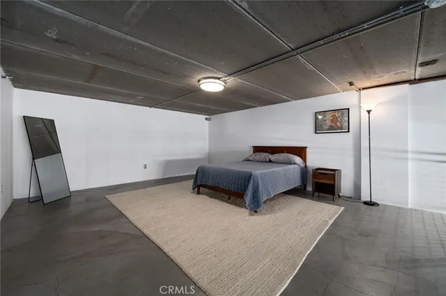 a spacious bedroom with a bed and a chair