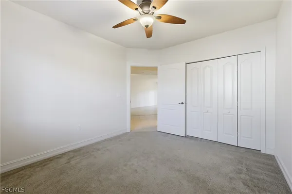 an empty room with chandelier fan