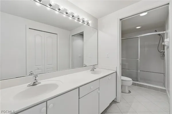 a bathroom with a double vanity sink mirror and toilet