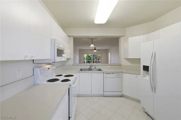 a kitchen with white cabinets and appliances