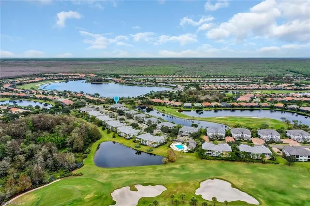 an aerial view of a golf course with a lake view