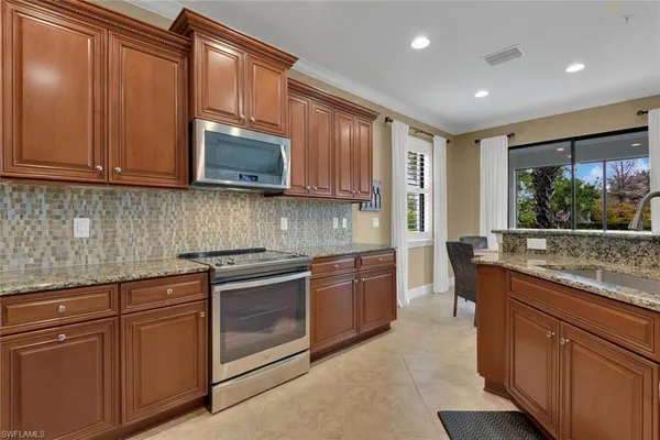 a kitchen with stainless steel appliances granite countertop wooden cabinets and a stove top oven