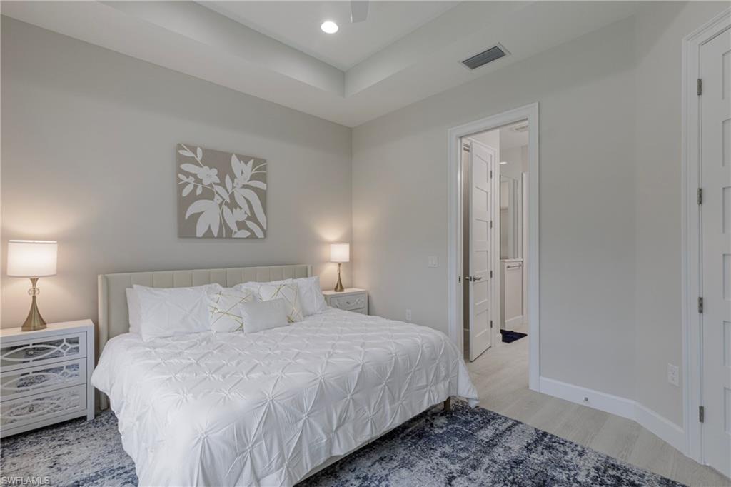 8909 Yucatan Court Naples, FL 34113 - Photo 9 of 36 a bedroom with a bed and a painting on the wall