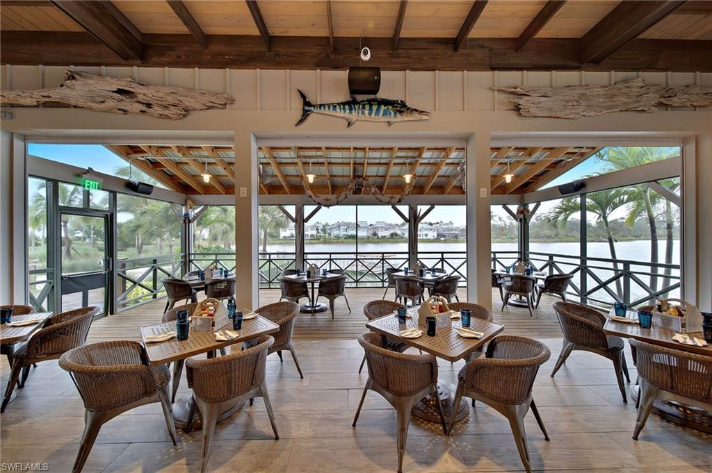 8909 Yucatan Court Naples, FL 34113 - Photo 27 of 36 a room with lots of tables a large window and chairs