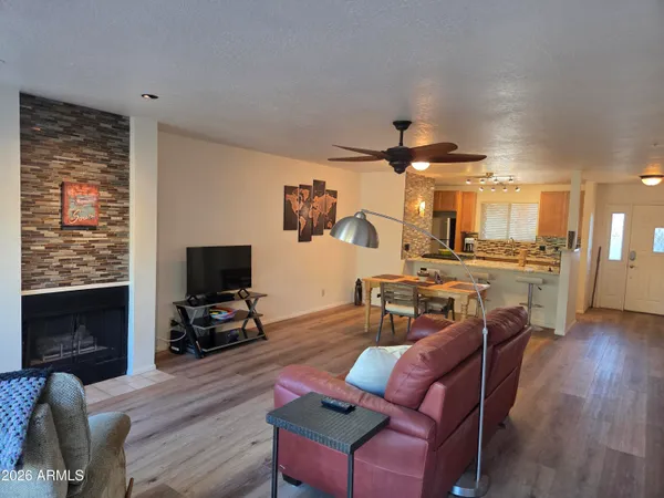 a living room with furniture a flat screen tv and kitchen view