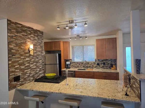 a kitchen with stainless steel appliances granite countertop a refrigerator and a stove