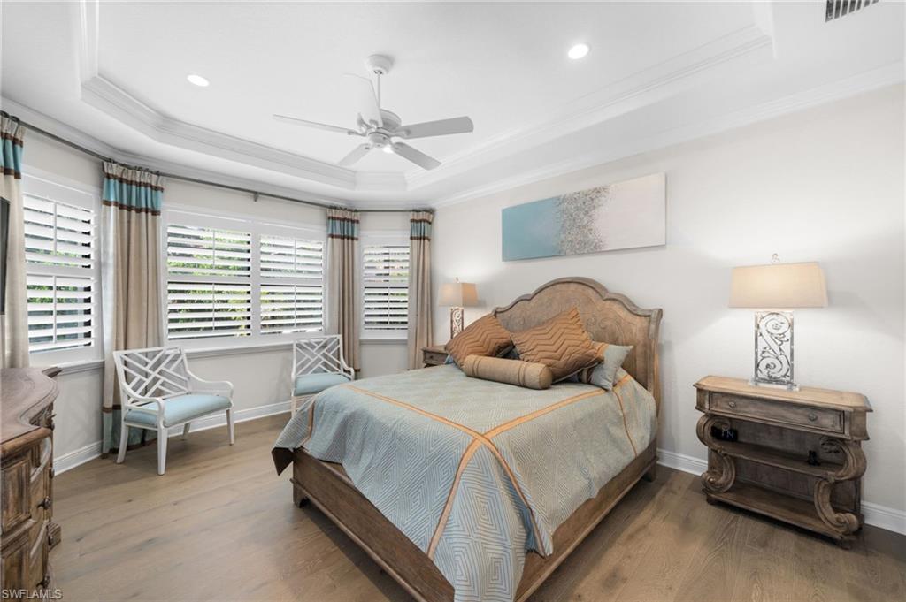 10067 Palazzo Drive Naples, FL 34119 - Photo 20 of 46 a bedroom with a bed and a chandelier