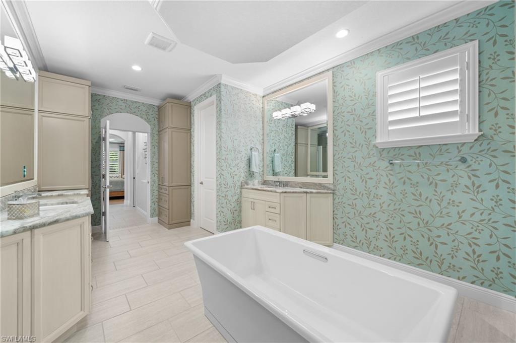 10067 Palazzo Drive Naples, FL 34119 - Photo 23 of 46 a bathroom with a tub a sink and a large mirror