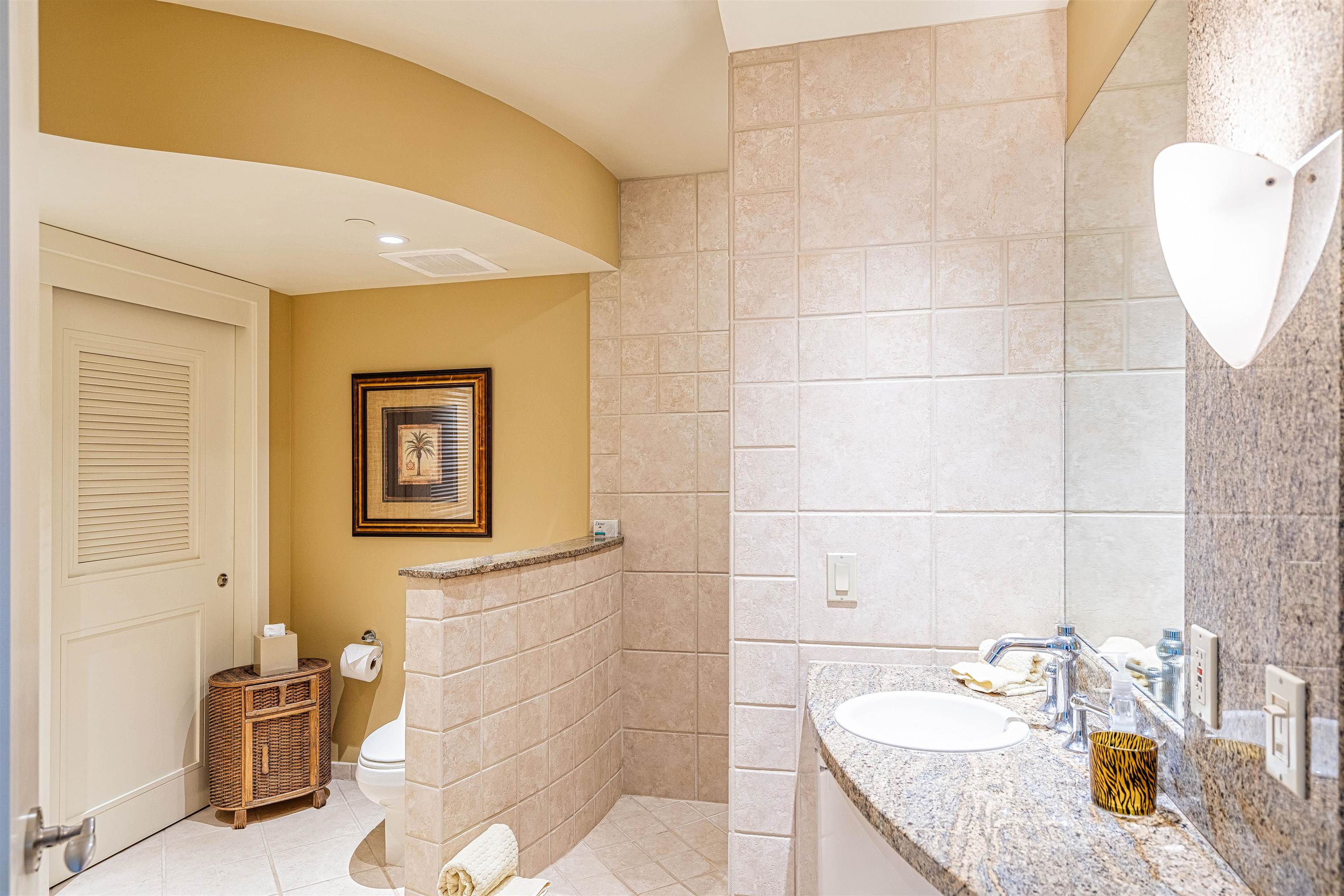 4955 Makena Road, Unit E301 Kihei, HI 96753 - Photo 17 of 22 a bathroom with a granite countertop sink a toilet and mirror