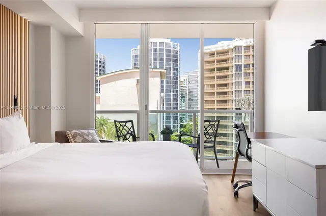 a bedroom with a bed and a table next to a window