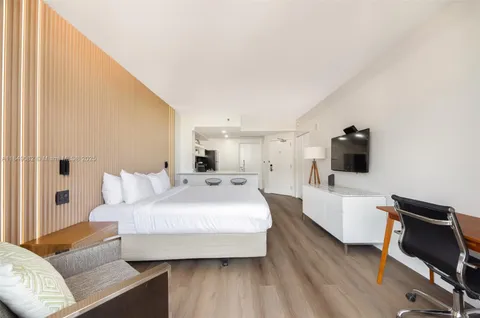 a spacious bedroom with a bed and wooden floor