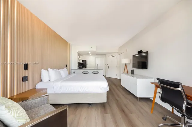 a spacious bedroom with a bed and wooden floor