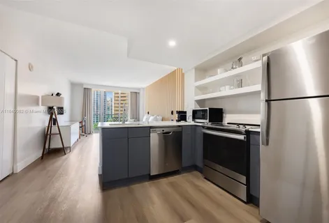 a kitchen with stainless steel appliances granite countertop a refrigerator a stove and a sink