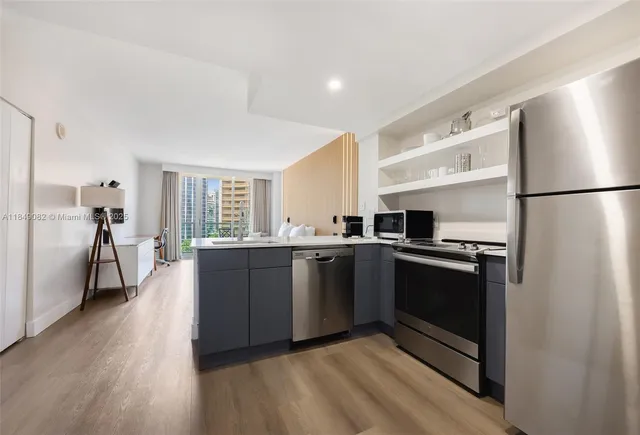 a kitchen with stainless steel appliances granite countertop a refrigerator a stove and a sink