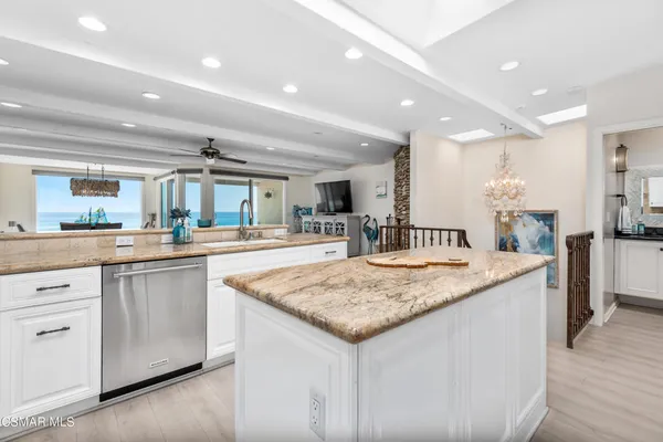 a kitchen with granite countertop kitchen island and white cabinets