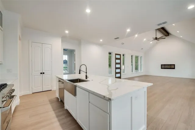 a kitchen with stainless steel appliances granite countertop a sink and a stove