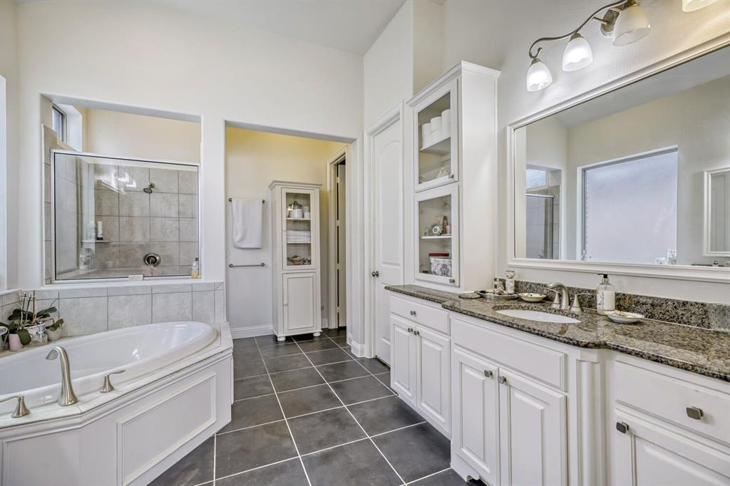 1425 Wildrye Ridge Celina, TX 75009 - Photo 21 of 32 a spacious bathroom with a granite countertop tub sink a mirror a shower and vanity