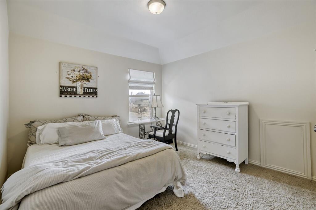 1425 Wildrye Ridge Celina, TX 75009 - Photo 25 of 32 a bedroom with a bed and a lamp on dresser