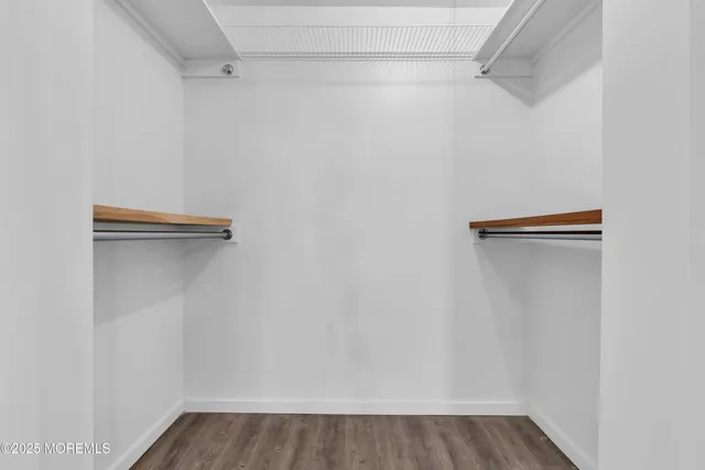 a view of empty room with wooden floor and windows