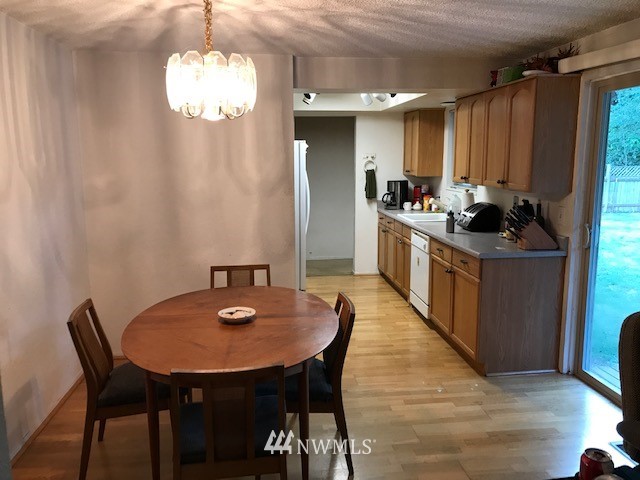 14225 169th Avenue Southeast Renton, WA 98059 - Photo 6 of 8 a kitchen with stainless steel appliances granite countertop a kitchen island a stove a table and chairs in it
