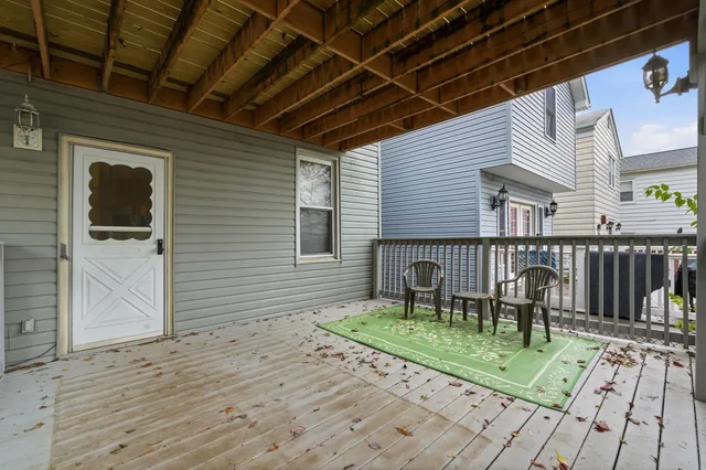 a porch with a table and chairs and wooden floor