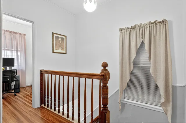 a view of a hallway with wooden floor and stairs