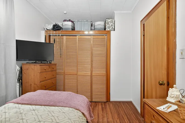 a bedroom with a bed and wooden floor