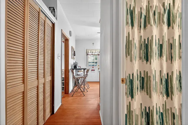 a view of a hallway with a chair and table in a balcony