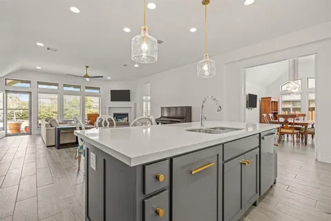 a dining room with furniture a chandelier and kitchen view